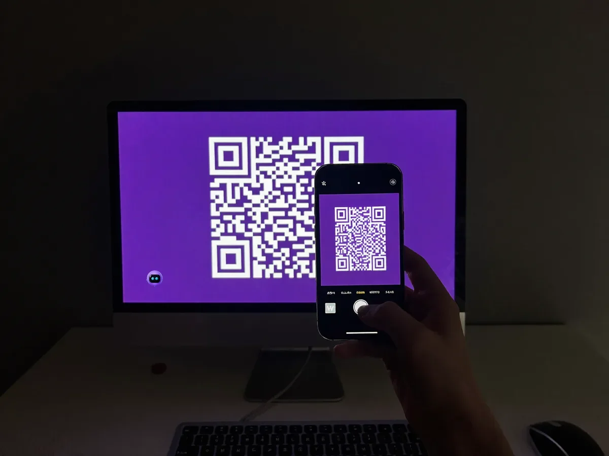 Telefon kamerası, PC monitöründeki menekşe zeminli beyaz QR kodu okutarak eşleşiyor